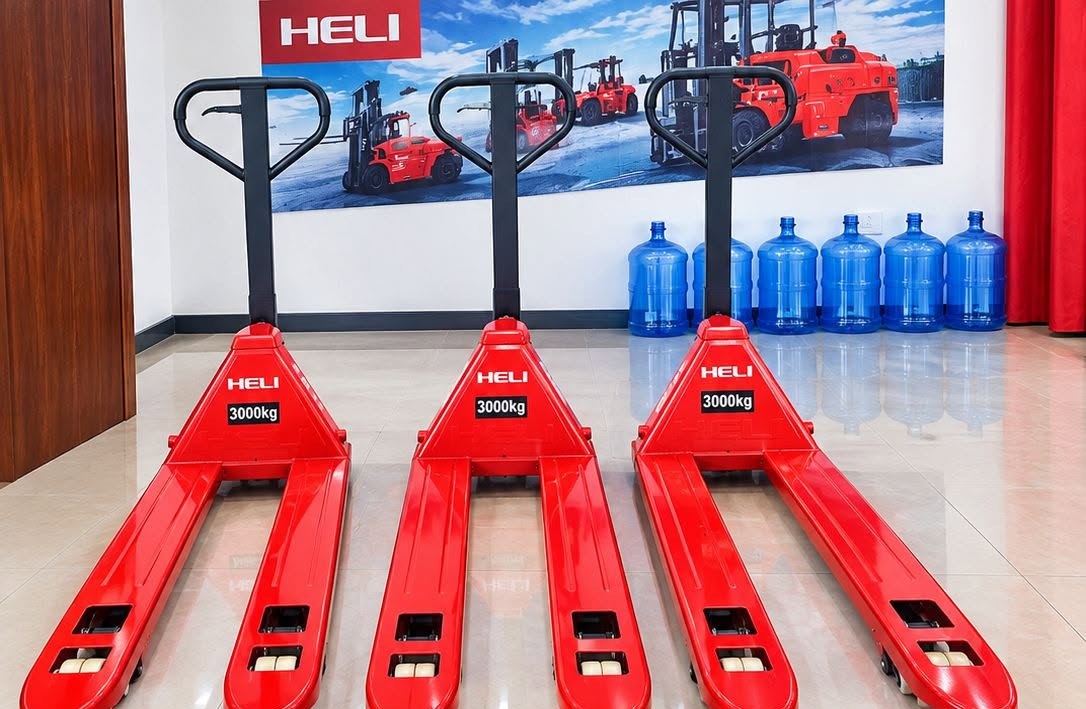 Three red HELI 3000kg pallet trucks